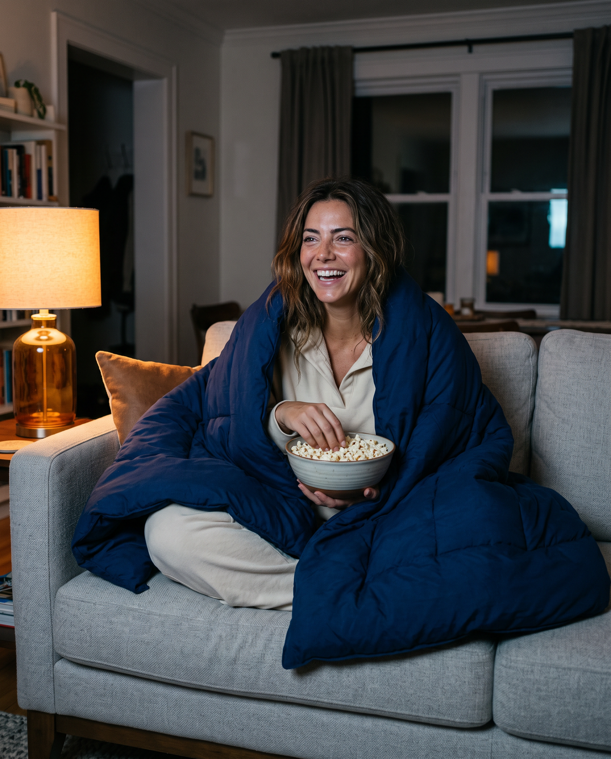 Wrapped in the navy comforter on the sofa